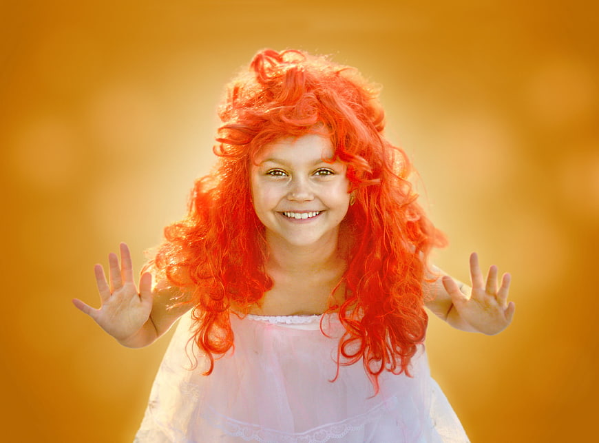 Happy Girl with Red Wig Smiling Against Golden Background