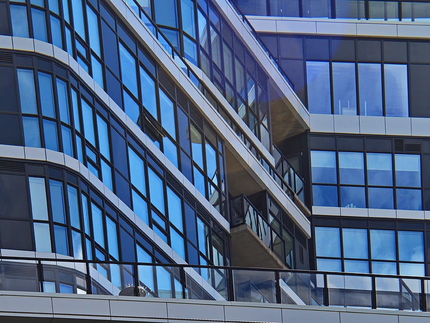 Modern Glass Office Building Facade with Blue Reflections