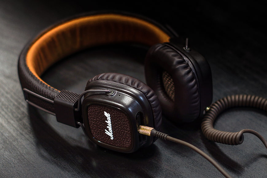 Black Over-Ear Headphones With Brown Leather Headband On Dark Surface