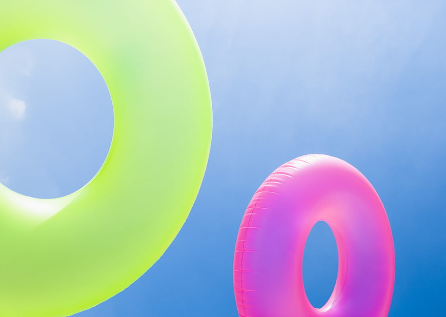 Colorful Inflatable Pool Rings Against Blue Sky