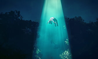 Woman floating in underwater beam of light