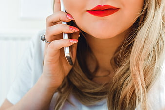 Close-up of woman with red lipstick talking on smartphone