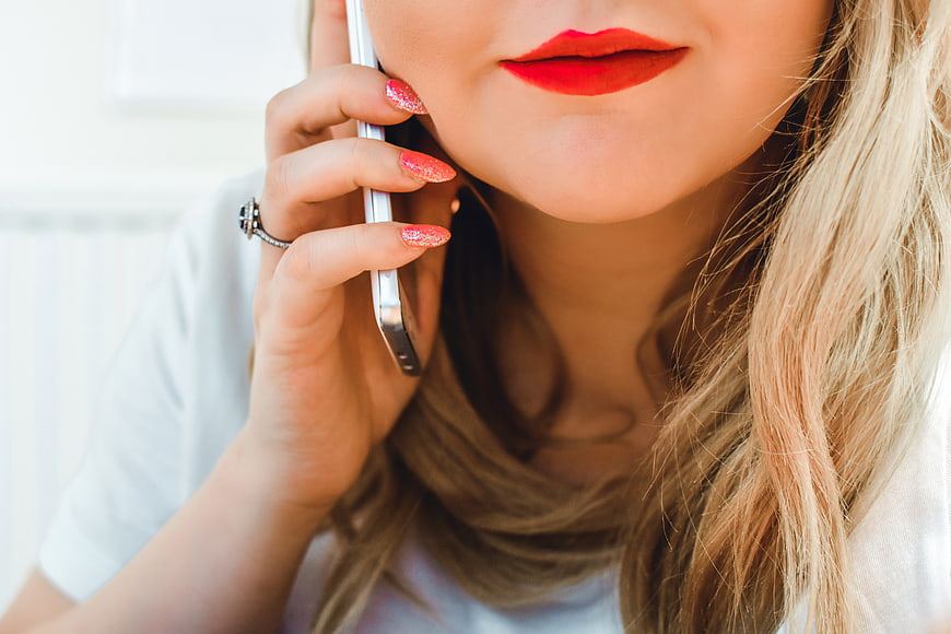 Close-up of woman with red lipstick talking on smartphone