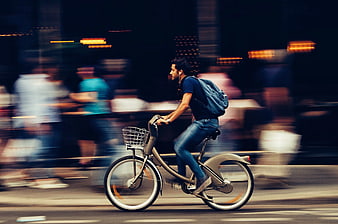 Man Riding Bicycle in City with Motion Blur