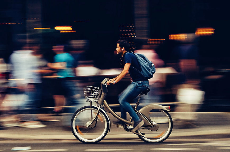 Man Riding Bicycle in City with Motion Blur