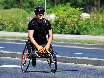 Athletic Man Riding Racing Wheelchair On Asphalt Road