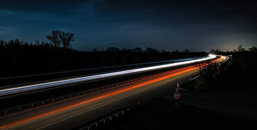 Nighttime highway light trails with red and white streaks