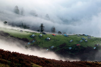 Misty Highland Village with Scattered Houses on Green Hills