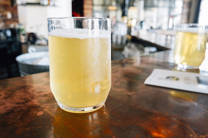 Cold Craft Beer in Glass on Rustic Bar Counter