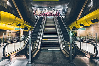 Symmetrical subway escalators with yellow ventilation ducts