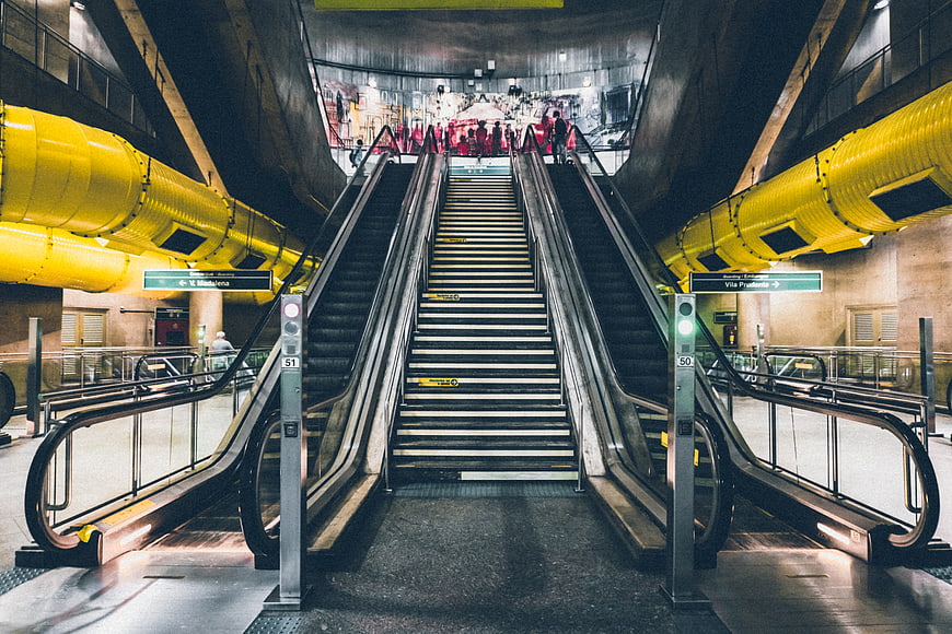 Symmetrical subway escalators with yellow ventilation ducts