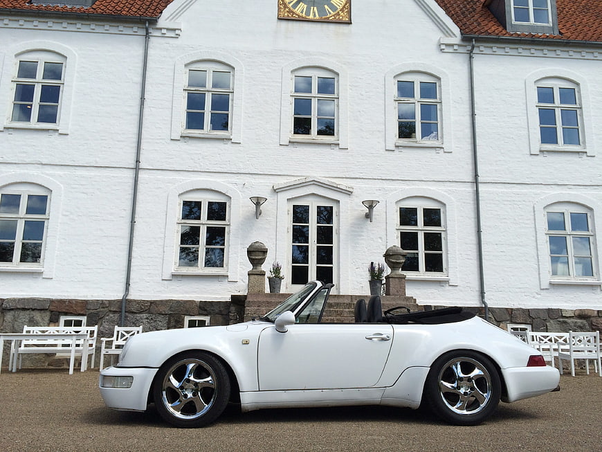 White Porsche 914 Convertible Parked In Front Of Historic White Building