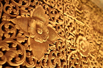 Close-up of ornate golden floral wood carving texture