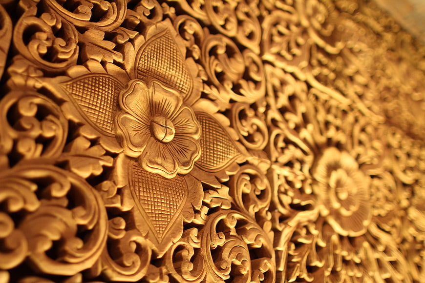 Close-up of ornate golden floral wood carving texture