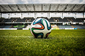 Soccer ball on grass in empty stadium
