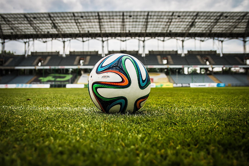 Soccer ball on grass in empty stadium