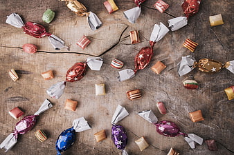 Top View of Colorful Wrapped Candies on Rustic Wood