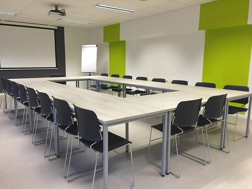 Modern Conference Room with U-Shaped Table and Green Walls
