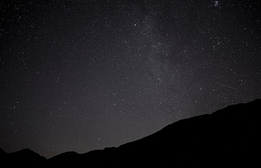 Starry Night Sky Over Mountain Silhouette