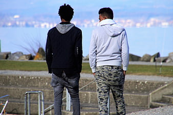 Two men standing by a lake looking at the city skyline