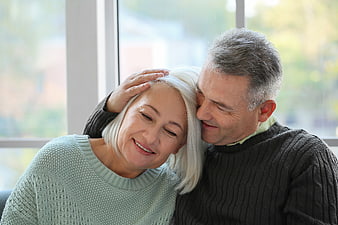 Senior couple embracing affectionately by window