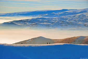Hikers on Snowy Mountain Ridge at Sunrise