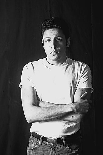 Black and white portrait of a young man with arms crossed
