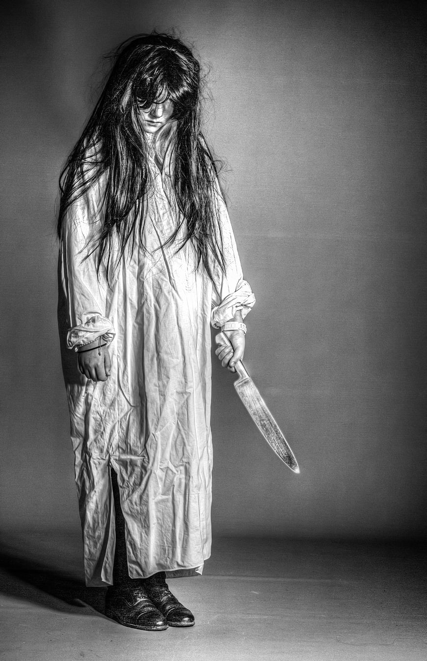 Scary woman in nightgown holding knife black and white