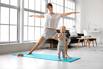 Mother and toddler doing yoga together in bright living room
