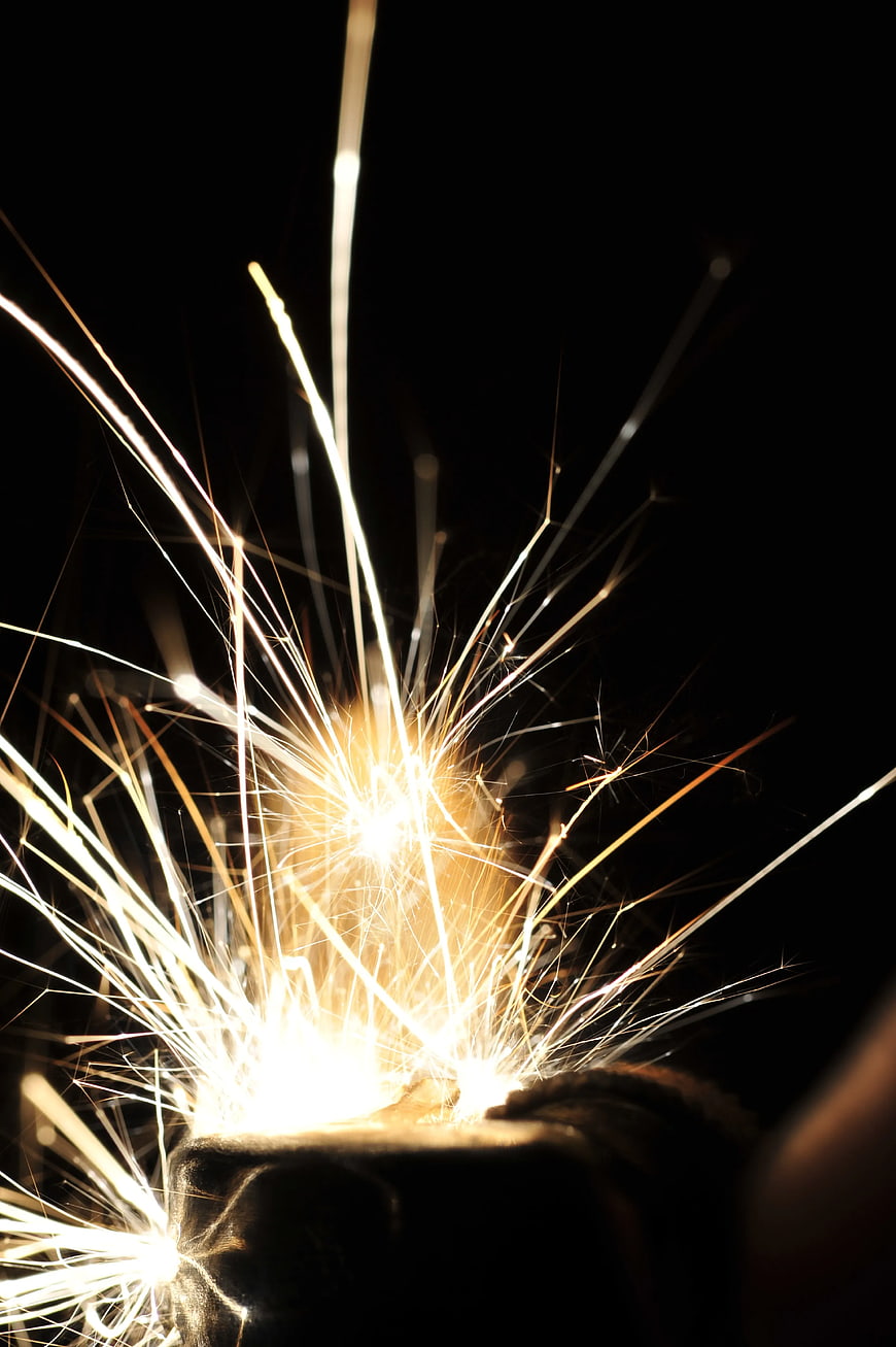 Bright Sparkler Burning Against Black Background