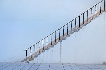 Minimalist White Staircase with Black Railing Against Blue Wall