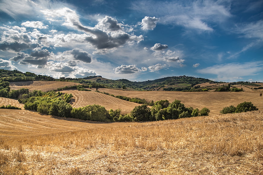 Golden Tuscan Hills Landscape with Blue Sky and Clouds