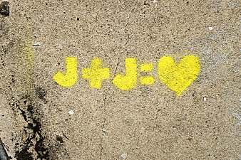 Yellow J+J Heart Graffiti on Concrete Wall