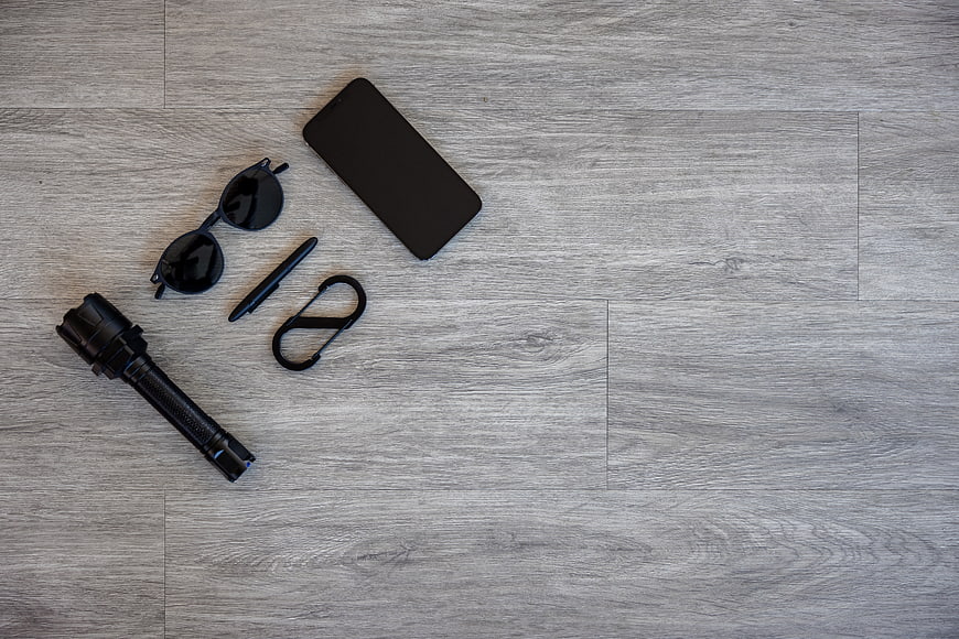 Black EDC Gear Flat Lay on Gray Wood Background