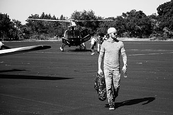Man walking on airport tarmac with helicopter in background