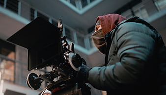 Cinematographer operating professional camera on film set