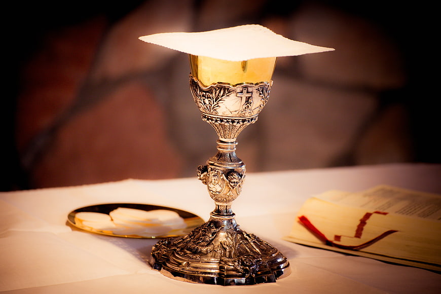 Silver Chalice with Paten and Bible on Altar