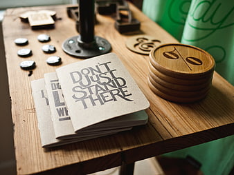 Handmade wooden coasters and printed cards on rustic table
