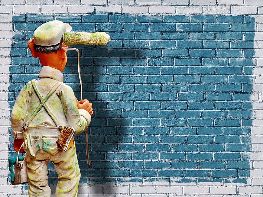 Painter Figurine Painting Blue Brick Wall Background
