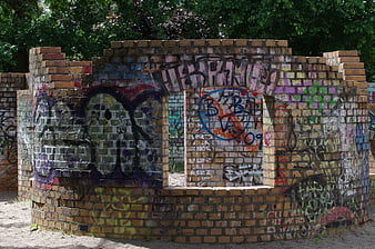 Circular brick structure covered in colorful graffiti art