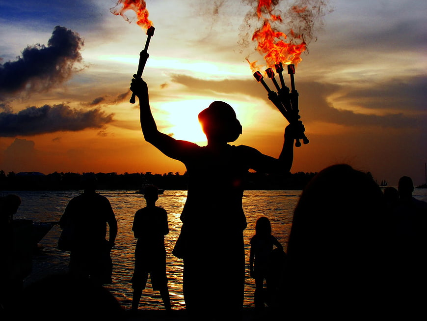 Silhouette of Fire Performer with Torches at Sunset