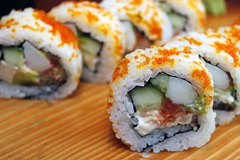 Close-up of fresh sushi rolls with roe on bamboo mat