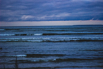 Moody Blue Ocean Waves Under Stormy Clouds