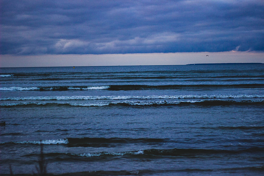 Moody Blue Ocean Waves Under Stormy Clouds