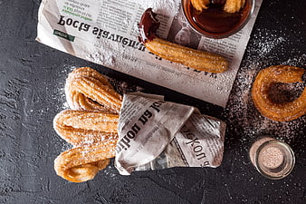 Overhead view of churros with chocolate sauce and cinnamon sugar