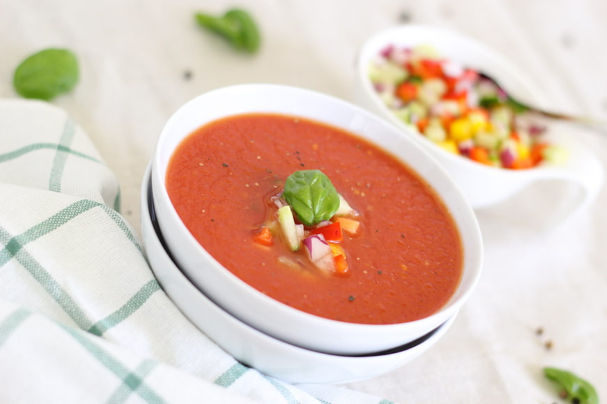 Fresh Tomato Soup with Basil and Vegetable Garnish in White Bowl