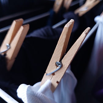 Close-up of wooden clothespins on a clothesline with laundry