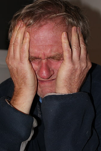 Senior man holding head in despair and emotional pain