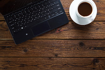 Top view of laptop and coffee on wooden table workspace
