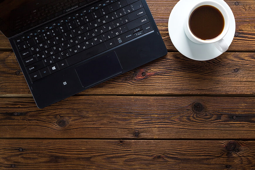 Top view of laptop and coffee on wooden table workspace